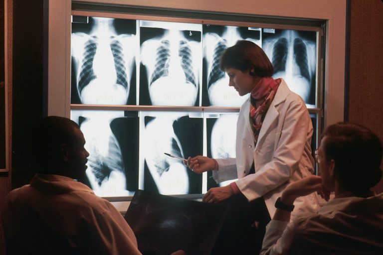 Radiologie au maroc- doctor talking to a patient in front of a x - ray